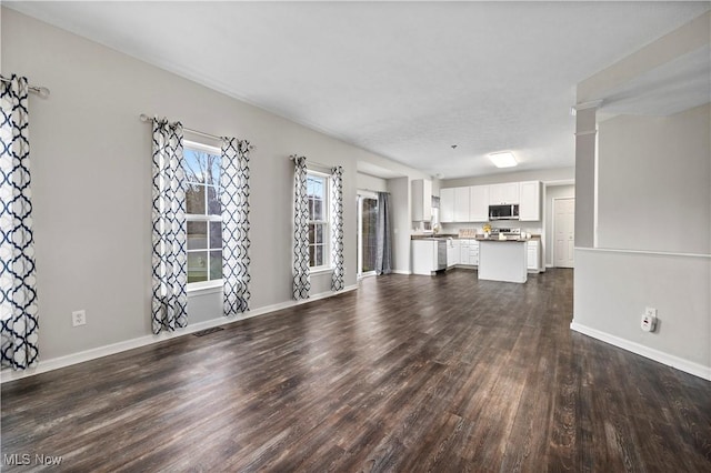 unfurnished living room with dark wood-type flooring