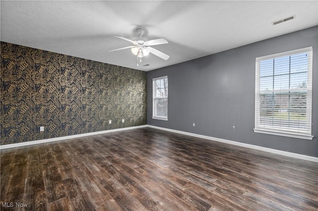 unfurnished room featuring dark hardwood / wood-style floors and a wealth of natural light