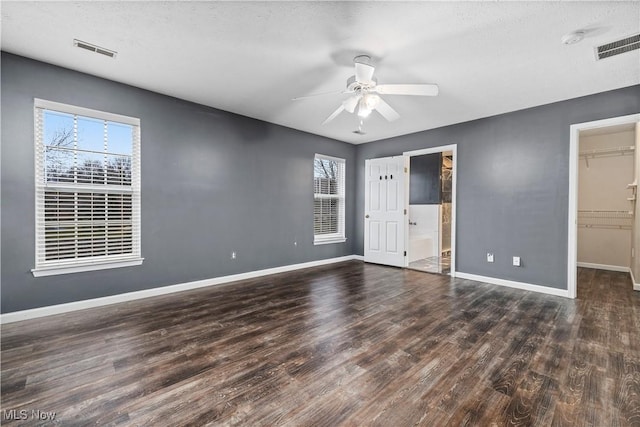 spare room featuring a textured ceiling, ceiling fan, and dark wood-type flooring