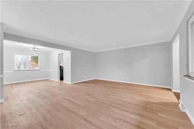 unfurnished living room featuring light hardwood / wood-style floors and a notable chandelier