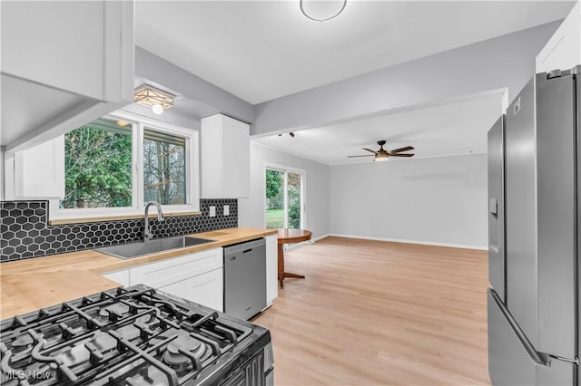 kitchen with white cabinetry, butcher block counters, and backsplash