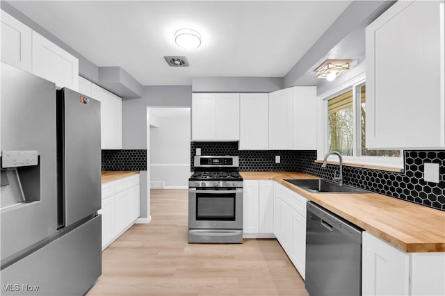 kitchen featuring white cabinetry, stainless steel appliances, and light wood-type flooring