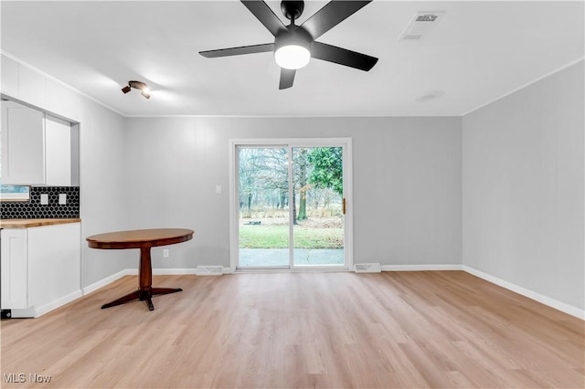 interior space featuring light wood-type flooring, ceiling fan, and crown molding