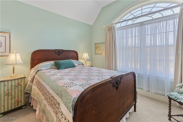 bedroom featuring light colored carpet and vaulted ceiling