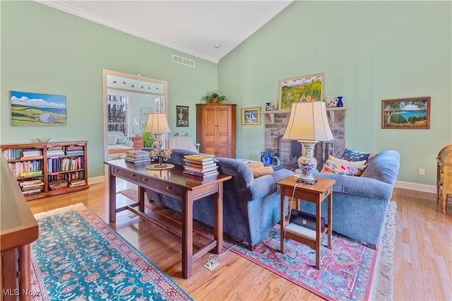 living room featuring crown molding, high vaulted ceiling, and light hardwood / wood-style flooring