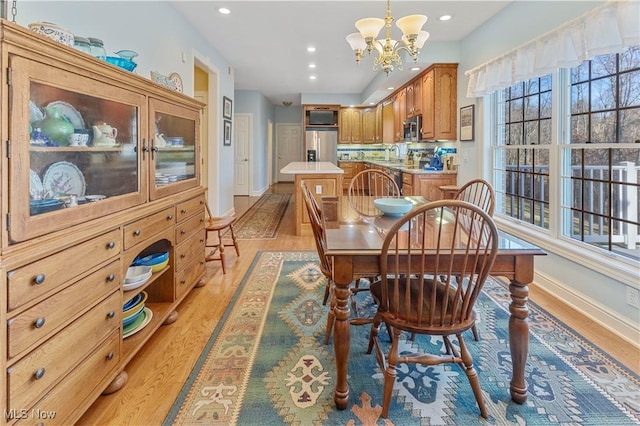 dining area with a notable chandelier and light hardwood / wood-style flooring