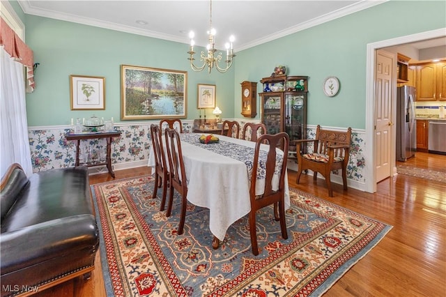 dining space featuring a chandelier, crown molding, and light hardwood / wood-style flooring