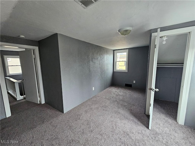 unfurnished bedroom featuring carpet floors, a closet, and multiple windows