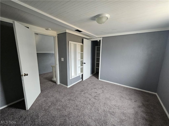 unfurnished bedroom with a closet and dark carpet