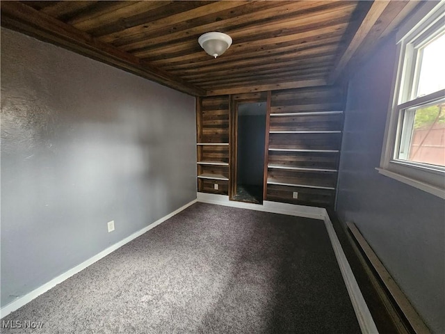 carpeted spare room featuring a healthy amount of sunlight and wooden ceiling