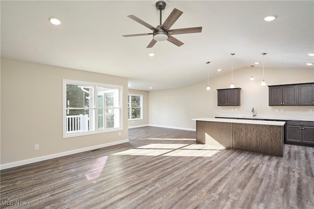 kitchen featuring dark hardwood / wood-style flooring, a kitchen island, vaulted ceiling, and sink