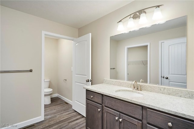 bathroom featuring vanity, toilet, and wood-type flooring