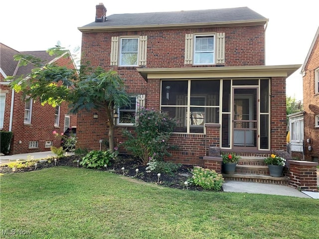 view of front of home featuring a front lawn and a sunroom