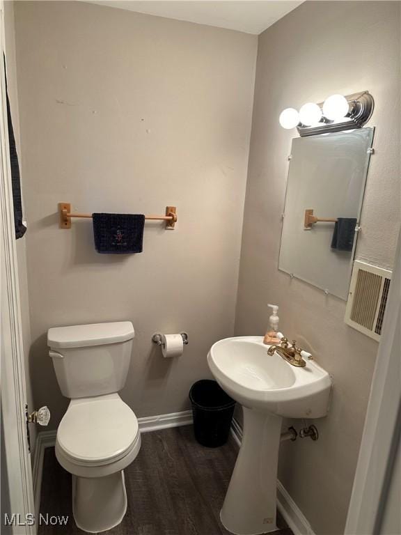 bathroom featuring hardwood / wood-style flooring and toilet