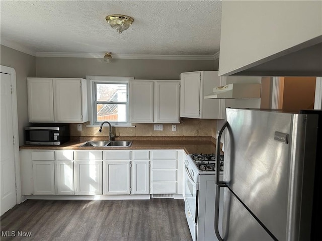 kitchen featuring white cabinets, sink, dark hardwood / wood-style floors, ornamental molding, and appliances with stainless steel finishes