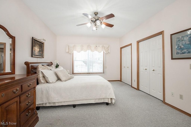 carpeted bedroom featuring ceiling fan and two closets