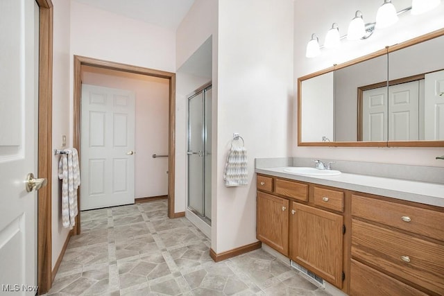 bathroom featuring vanity and a shower with door