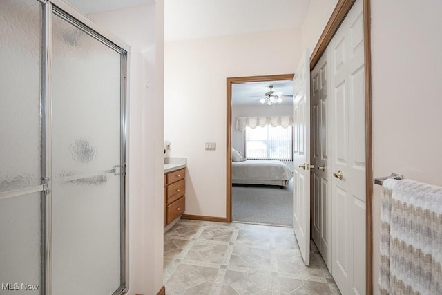 bathroom with ceiling fan, a shower with door, and vanity