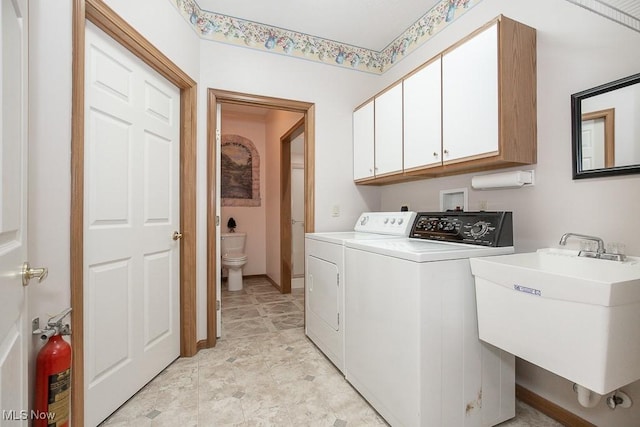 laundry area with cabinets, separate washer and dryer, and sink