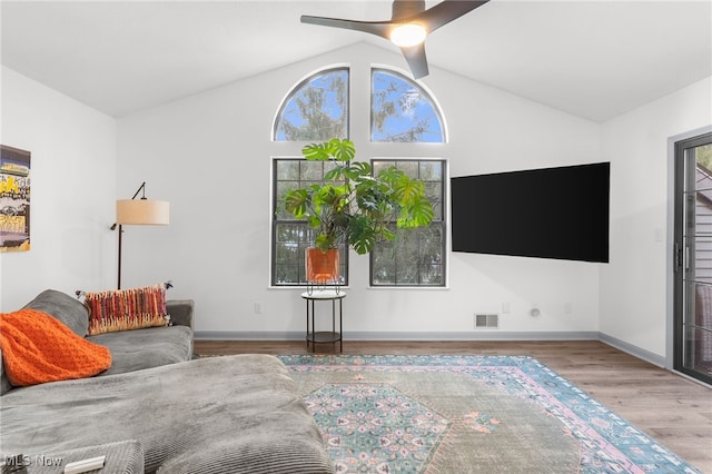 living room featuring ceiling fan, wood-type flooring, and vaulted ceiling