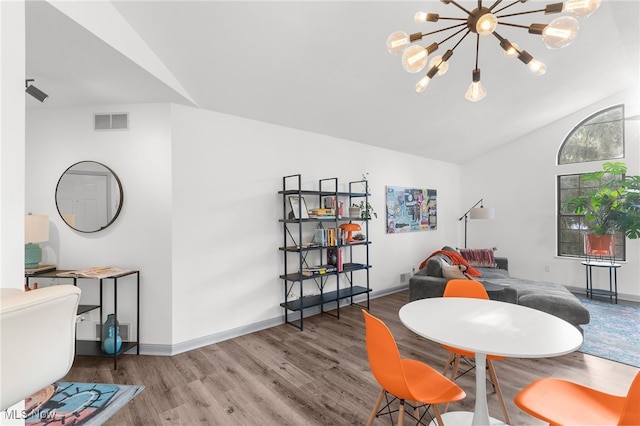 dining room with a chandelier, lofted ceiling, and wood-type flooring