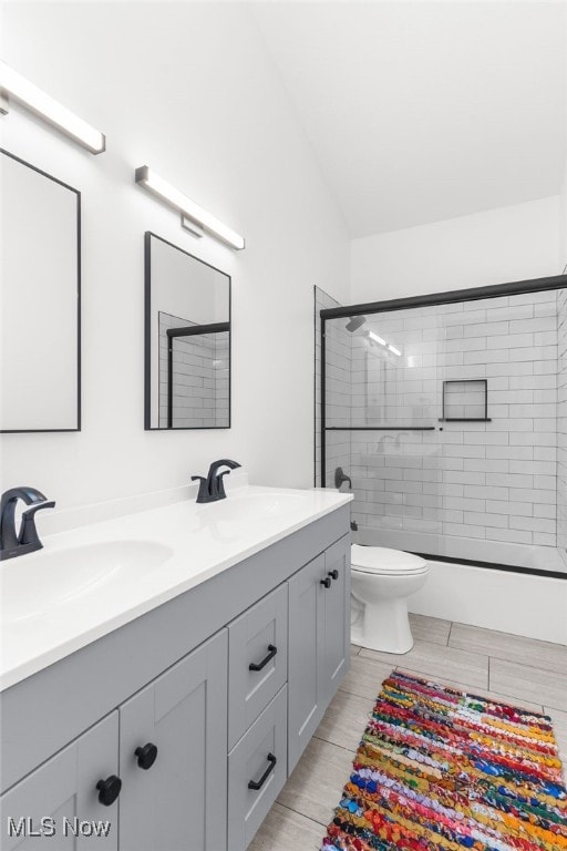 bathroom with vanity, toilet, and vaulted ceiling