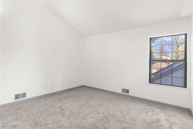 spare room featuring lofted ceiling and carpet floors