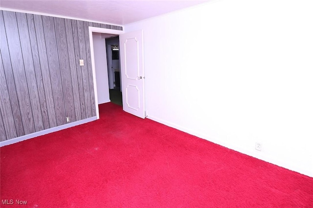 carpeted empty room with wood walls and ornamental molding