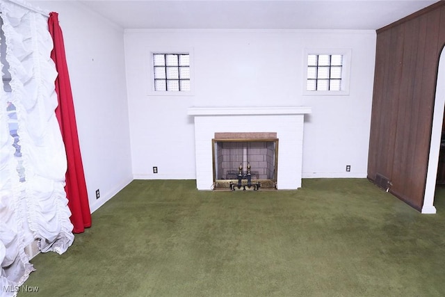 unfurnished living room featuring a fireplace, a healthy amount of sunlight, and dark carpet