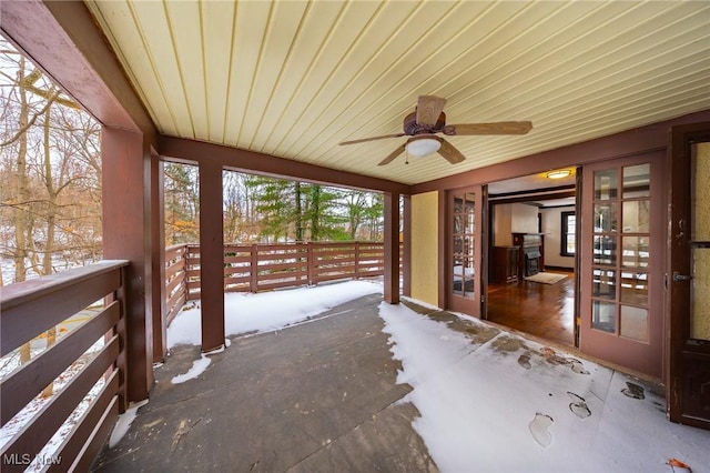 unfurnished sunroom featuring ceiling fan