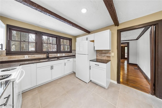 kitchen featuring tasteful backsplash, white appliances, sink, beam ceiling, and white cabinetry