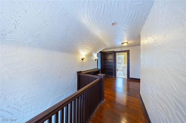 hallway featuring dark hardwood / wood-style flooring and lofted ceiling