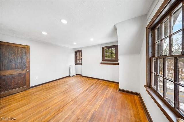 spare room with hardwood / wood-style floors and radiator heating unit