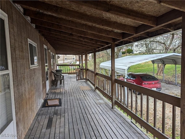 wooden terrace featuring a porch and a carport