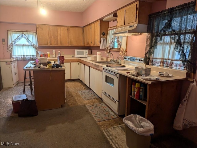 kitchen with carpet flooring, a center island, white appliances, and sink