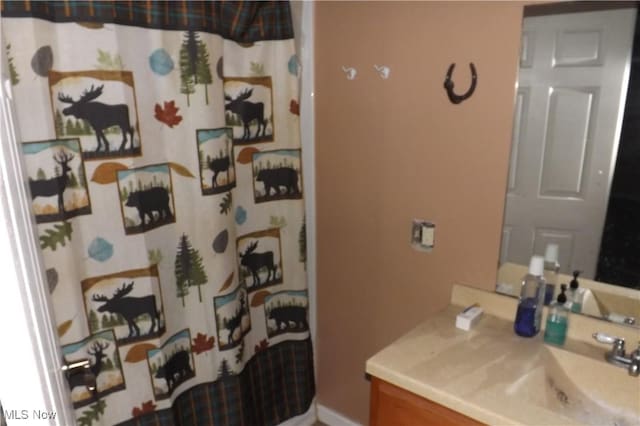 bathroom featuring a shower with shower curtain and vanity