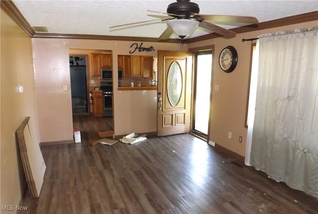 interior space featuring ornamental molding, stainless steel appliances, ceiling fan, and dark wood-type flooring