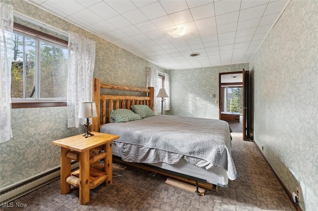 bedroom with carpet floors, a baseboard radiator, and multiple windows