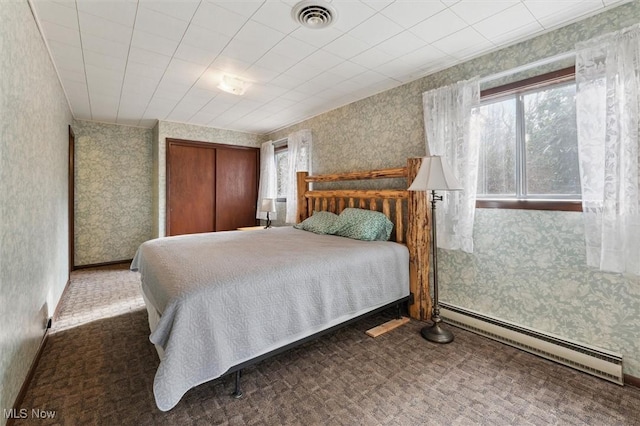 bedroom with a baseboard radiator and dark carpet