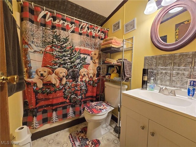 bathroom with tile patterned floors, vanity, vaulted ceiling, and toilet