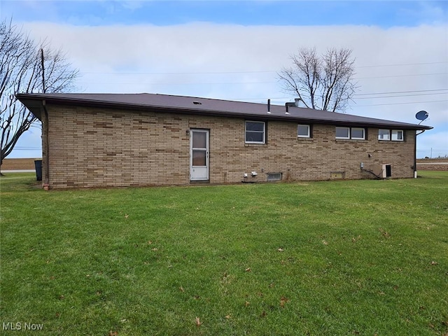 rear view of property featuring a lawn and central AC