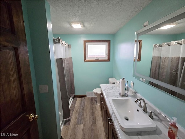 bathroom featuring a shower with shower curtain, vanity, a textured ceiling, and hardwood / wood-style flooring