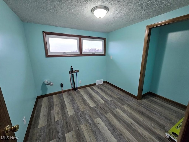 interior space with a textured ceiling and dark hardwood / wood-style floors