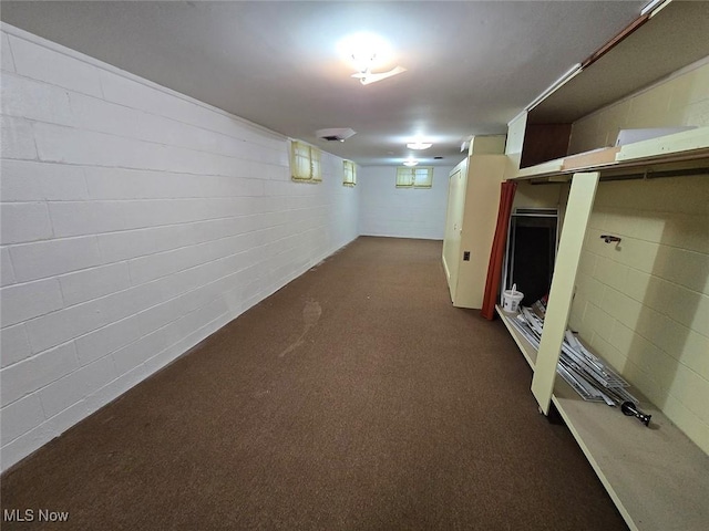 basement featuring dark colored carpet