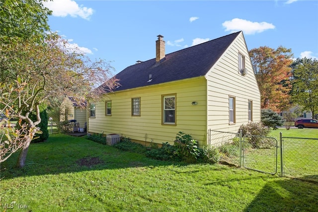 view of side of home with central air condition unit and a yard