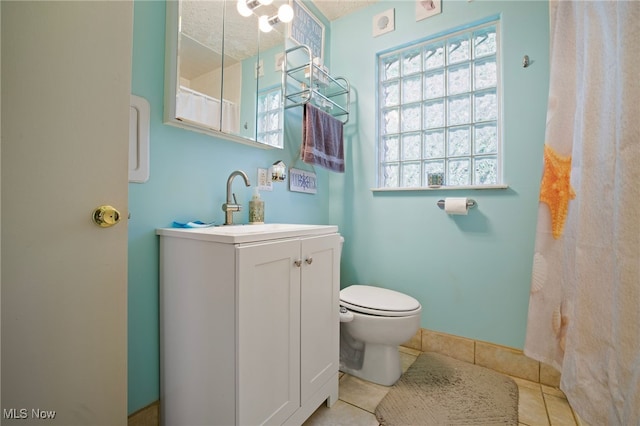 bathroom featuring tile patterned floors, vanity, a textured ceiling, and toilet