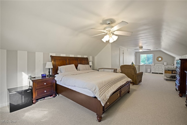 bedroom with ceiling fan, light colored carpet, and vaulted ceiling