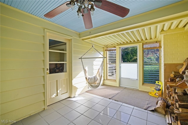 unfurnished sunroom featuring ceiling fan and wood ceiling