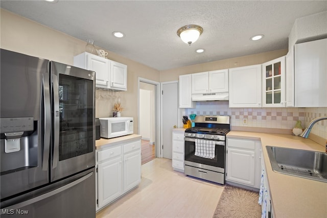 kitchen with sink, white cabinets, and stainless steel appliances