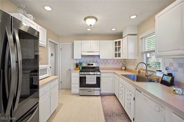 kitchen featuring backsplash, white cabinetry, sink, and stainless steel appliances